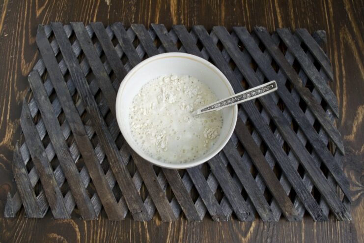 Whisking together smetana, flour, and water to create a creamy thickener A white creamy mixture of smetana, flour, and water in a small bowl.