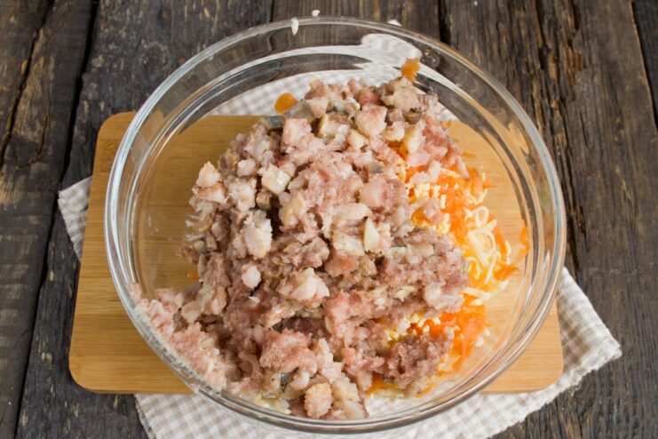 Incorporating minced herring for a savory flavor Minced herring fillet being added to the bowl with other filling ingredients.