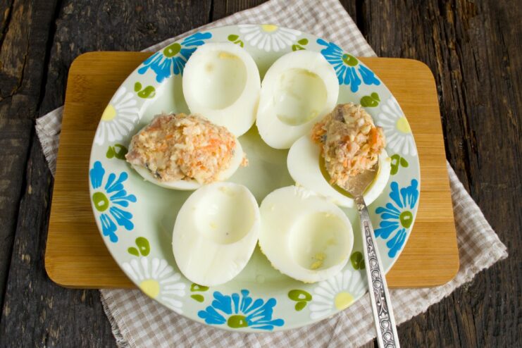 Generously stuffing egg whites with the savory herring filling Boiled egg white halves being filled with the herring and cheese mixture.