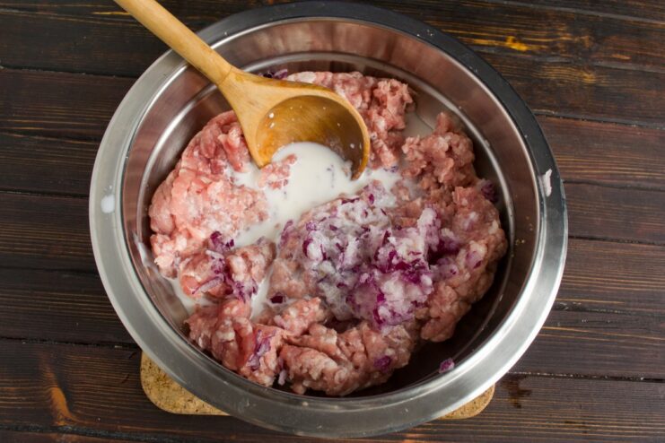 Seasoning the Meat Mixture for Extra Juiciness Cream and spices being added to a bowl of ground meat.