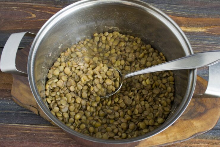 Cooking the green lentils until soft Green lentils cooking in a pot of water on the stove.