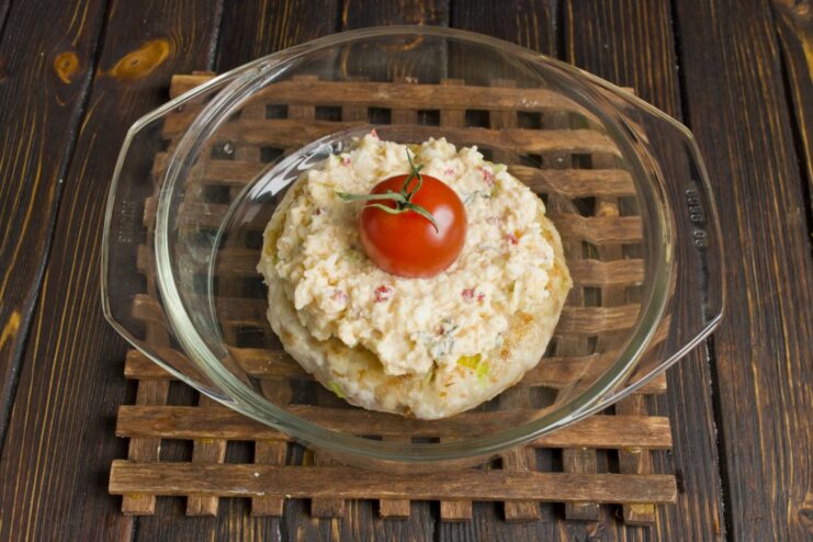 Assembling the Kotlety with Topping and Cherry Tomato Fried meat patties topped with a generous layer of cheese mixture and a cherry tomato.