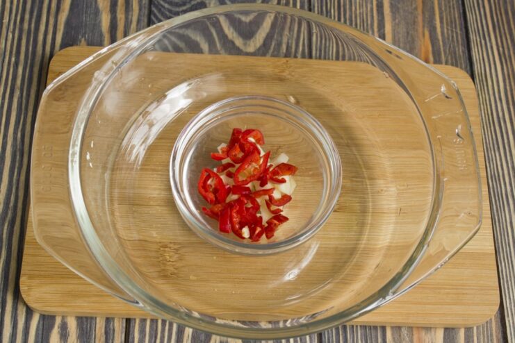Creating an aromatic base with garlic, chili, and ginger Minced garlic, chili, and ginger being stir-fried in a hot wok.
