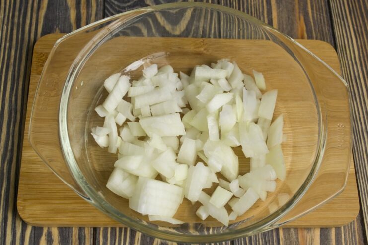 Sautéing onions until fragrant and translucent Chopped onions being added to the aromatics in the wok.