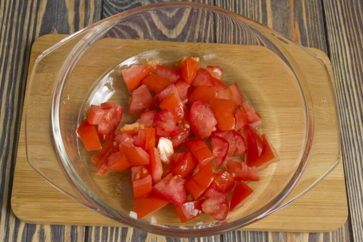 Incorporating fresh tomatoes for moisture and flavor Diced peeled tomatoes being added to the chicken and vegetable mix in the wok.