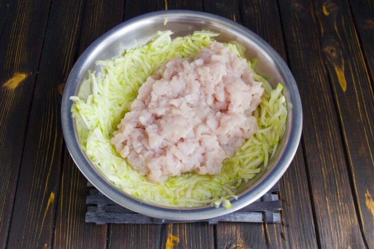 Combining Ground Chicken and Squeezed Zucchini for the Cutlet Mixture A bowl containing ground chicken and grated zucchini being mixed together.