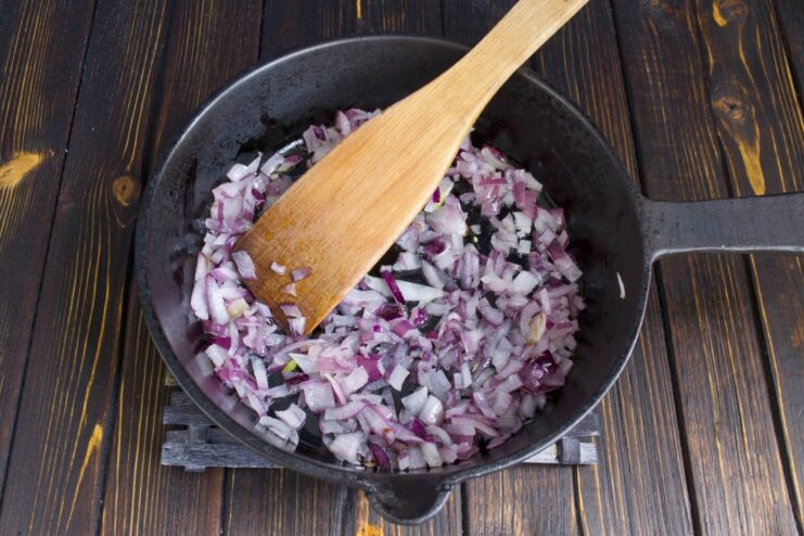 Creating a Flavor Base: Sautéing Onions Until Translucent Chopped red onions being sautéed in a skillet with butter and oil.