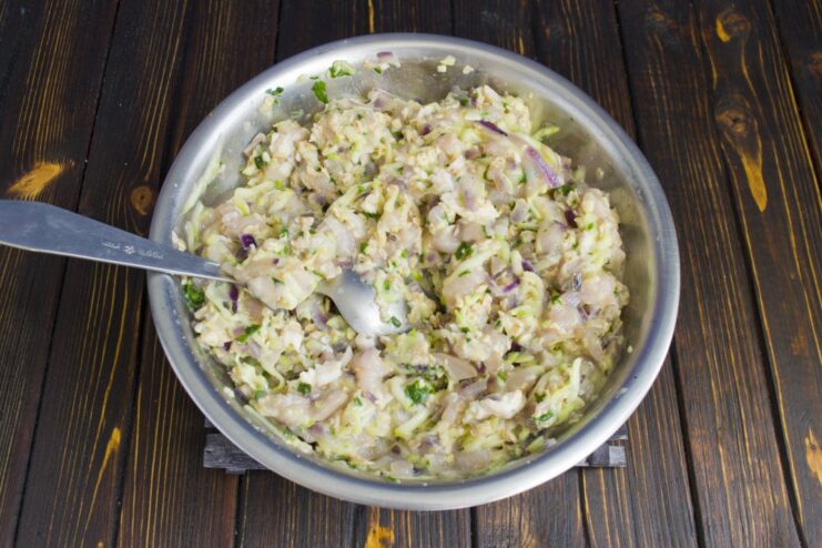 Combining All Ingredients for the Chicken and Mushroom Cutlets The sautéed mushroom and onion mixture being added to the bowl of ground chicken.