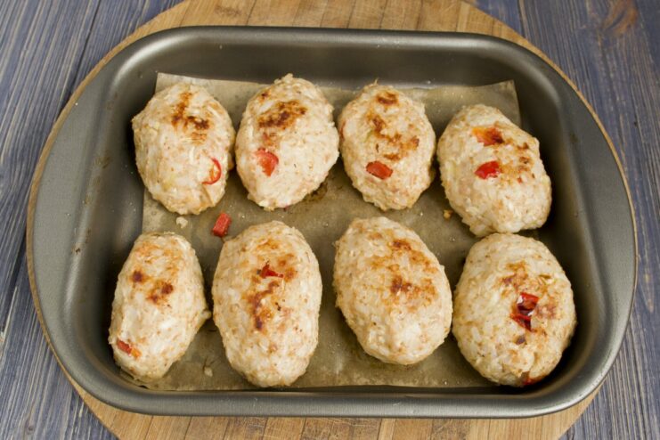 Baking Chicken Tefteli Until Golden Brown Baking sheet with chicken tefteli inside a hot oven.