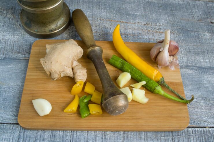 Making the Aromatic Paste for Chinese Stir-Fry A mortar and pestle with finely chopped garlic, ginger, and chili pepper, ready to be ground into a paste.