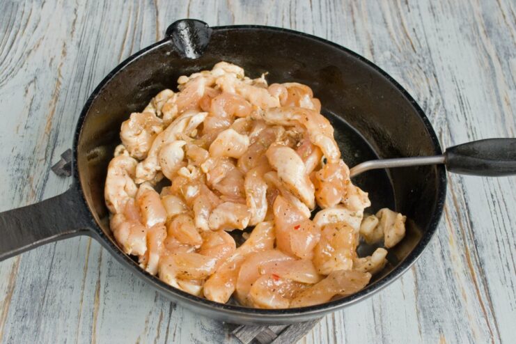 Quickly Searing the Chicken to Keep It Juicy Cooked pieces of chicken being transferred from a pan to a white bowl.