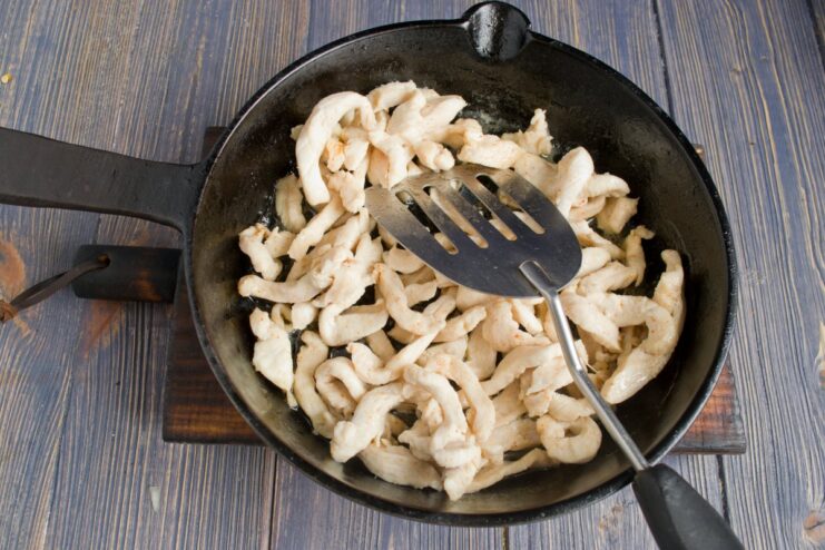 Searing Chicken Strips to Perfection Golden-brown chicken fillet strips being fried in a skillet.