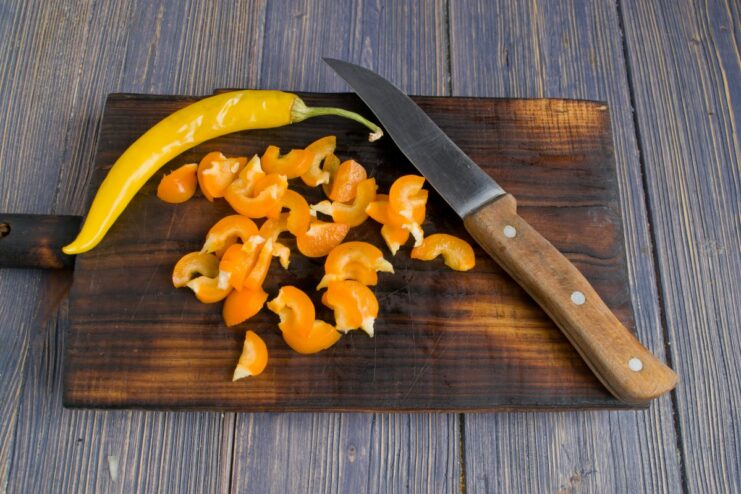 Adding a Kick with Fresh Chili Chopped bell pepper and chili pepper being stir-fried with other vegetables in a skillet.