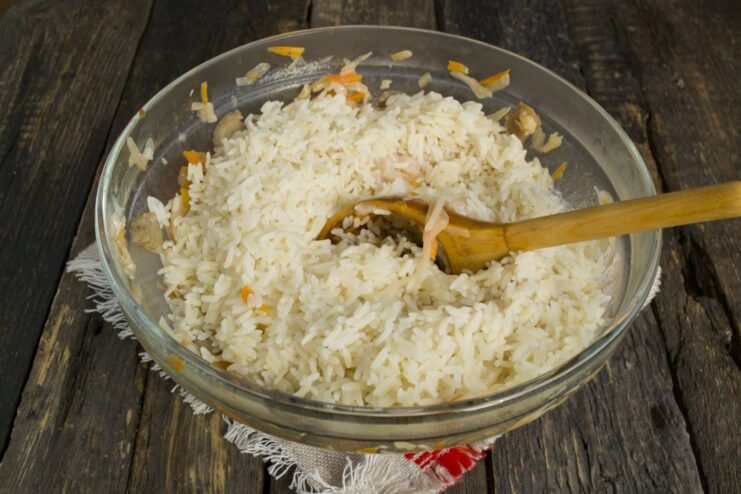 Step 3: Mix in cooked rice for the cabbage roll filling Adding a portion of cold cooked rice to the chicken and solyanka mixture.