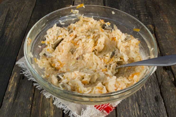 Step 4: Season and mix the filling for the lazy cabbage rolls Mixing the ground meat, rice, and solyanka in a bowl to create the filling.
