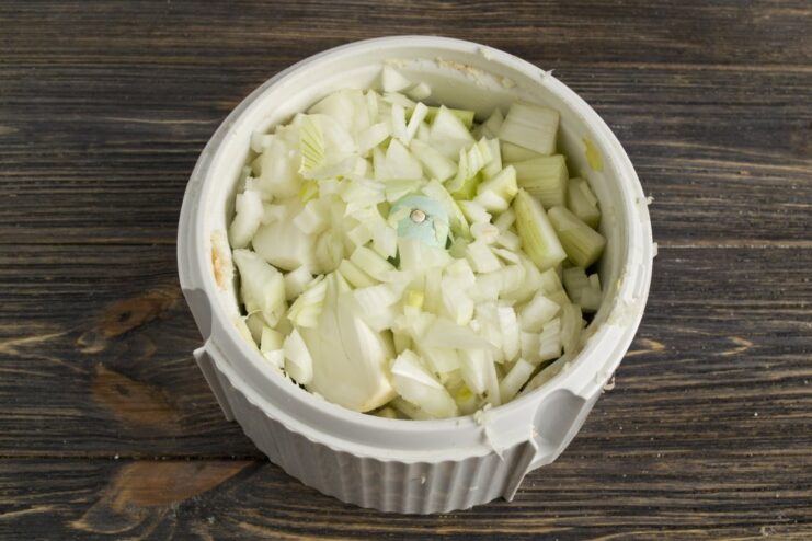 Adding Aromatic Vegetables to the Mix Finely chopped celery and onion in a bowl, ready to be added to the mince.