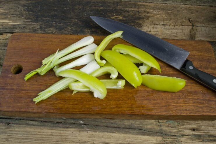 Preparing fresh vegetables for the meat patty mixture. Chopped bell peppers and green onions in a bowl.