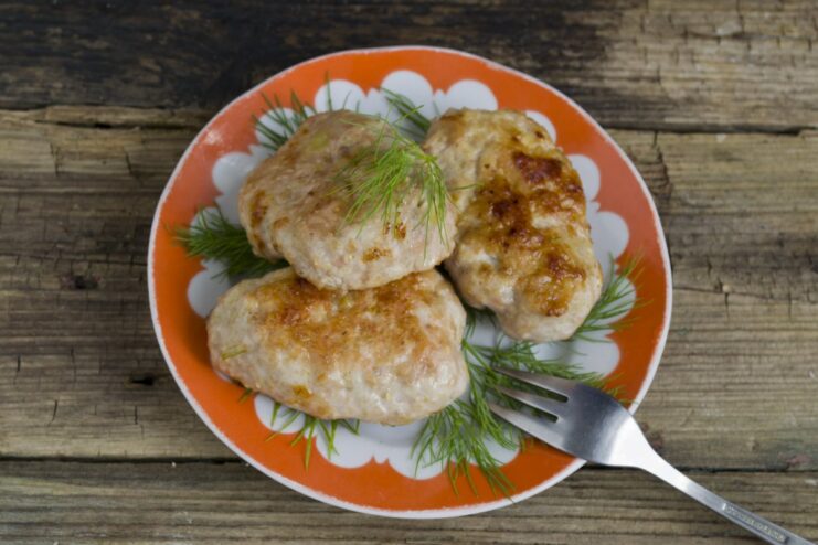 Serve the hot and juicy meat patties with a side of fresh salad. A close-up shot of the finished meat patties with bran and bell pepper on a plate.