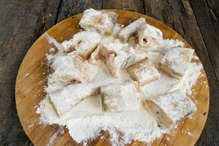 Pan-Searing Flour-Coated Pollock for a Golden-Brown Crust Flour-dredged pollock pieces being pan-fried until golden brown in a skillet.