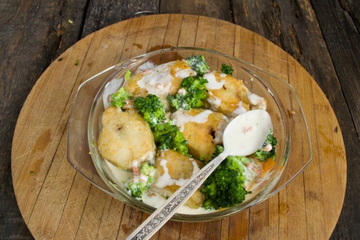 Creating a Creamy Sauce with Yogurt or Vegan Mayonnaise A creamy sauce made from yogurt or vegan mayonnaise being poured over the pollock and vegetables.