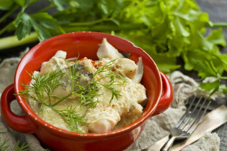 Delicious Pollock in Polish-Style Sauce Ready to Serve A plate of Pollock in Polish-Style Sauce, garnished with fresh herbs.