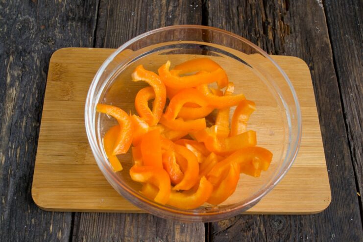 Adding Sweet Bell Peppers for Color and Flavor Strips of bell pepper being added to the simmering vegetables.
