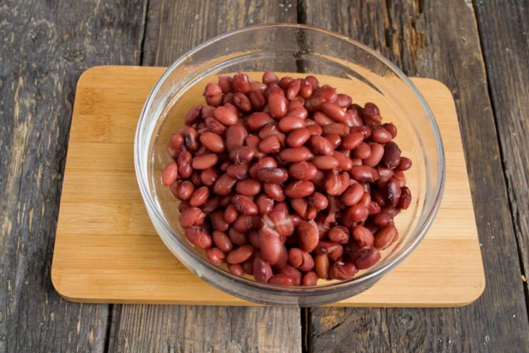 Adding Hearty Red Kidney Beans to the Ragout Cooked red kidney beans being added to the vegetable mixture in the pot.