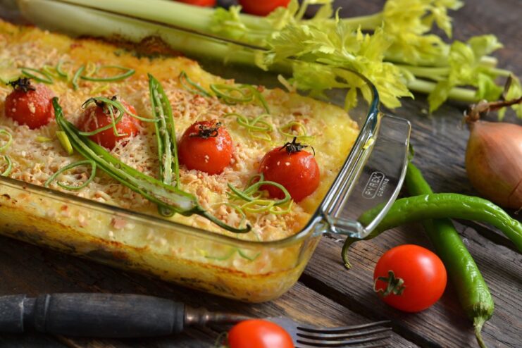 A whole chicken shepherd's pie with a golden cheese and peanut crust in a baking dish.