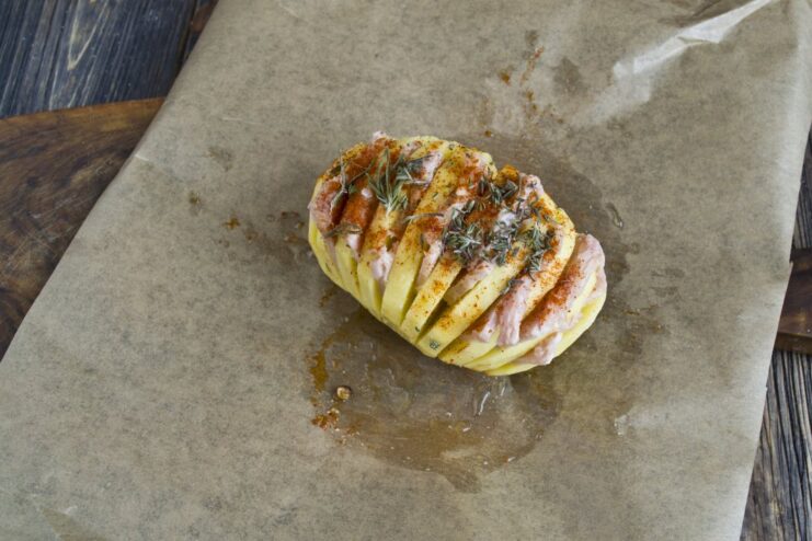 Step 5: Adding Spices for Flavor Sprinkling coarse sea salt, smoked paprika, and oregano over the accordion potato.