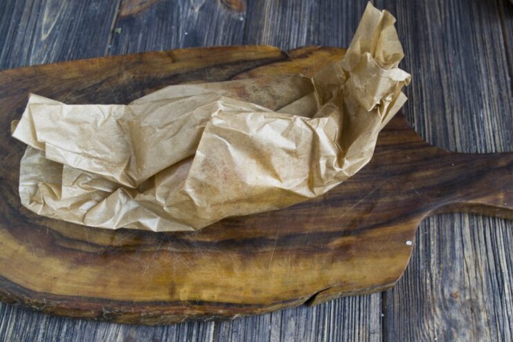 Step 6: Wrapping the Potato in Parchment Paper The seasoned accordion potato being wrapped in parchment paper like a candy.