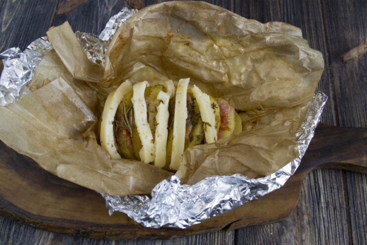 Step 8: Adding Cheese for a Golden Crust Placing sticks of hard cheese on the partially baked accordion potato.