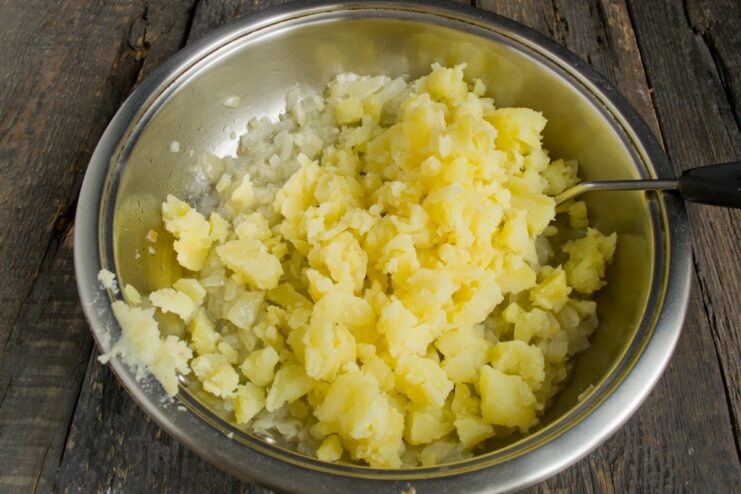 Step 4: Combining potato and onion for the filling Chopped potato flesh being added to the pan with caramelized onions.