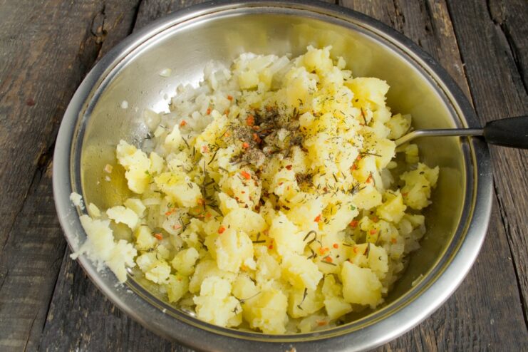 Step 5: Seasoning the potato filling Spices being added to the potato and onion mixture in a pan.