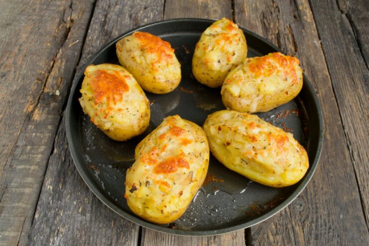Step 8: Baking the stuffed potatoes until golden Stuffed potatoes on a baking sheet in the oven, topped with melting cheese.