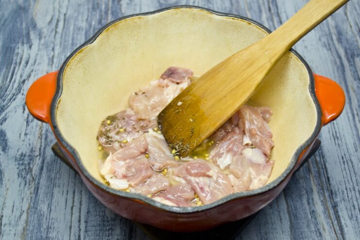 Searing Chicken Pieces Until Golden Brown Pieces of chicken being seared to a golden-brown crust in a Dutch oven.