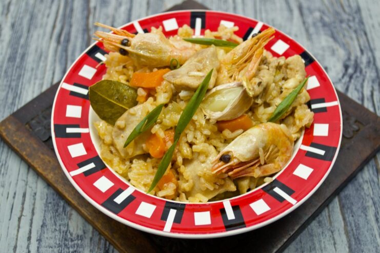 The Finished Chicken and Shrimp Plov, Ready to Enjoy A serving of hot chicken and shrimp plov in a bowl, garnished with fresh herbs.