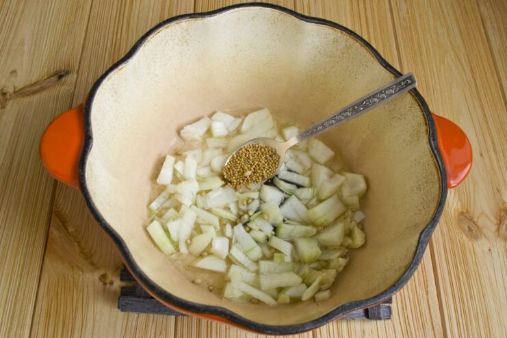 Toasting Spices to Release Their Aroma for the Pilaf Coriander and mustard seeds being added to the sautéed onions in the braiser.