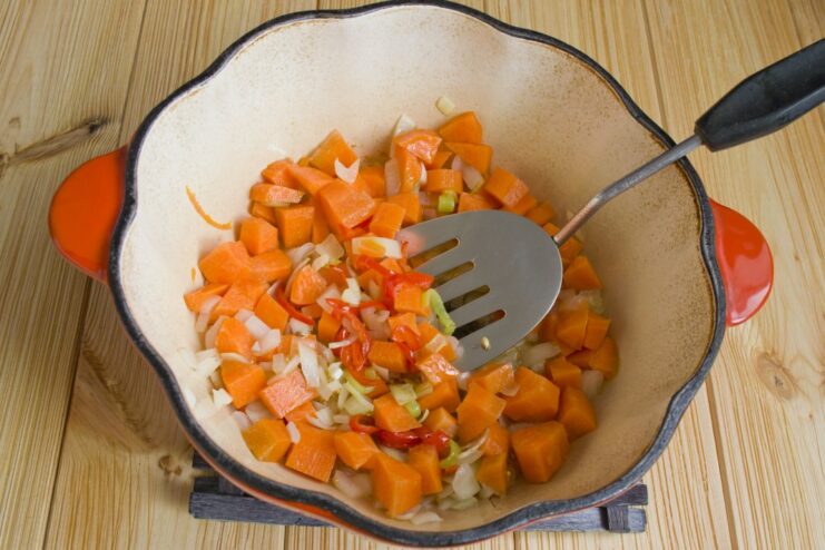Cooking the Carrots Until Tender-Crisp Diced carrots being added to the braiser with other vegetables and spices.