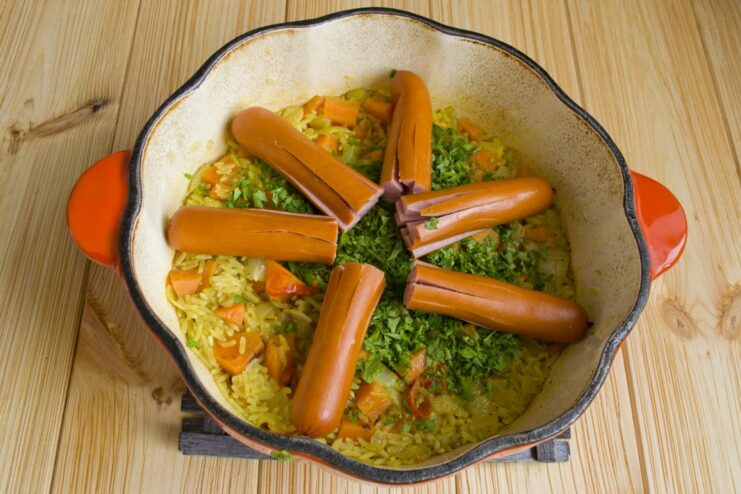 Creating the Fun Sausage Octopuses for the Plov Sausages, sliced to look like octopuses, being placed on top of the rice.