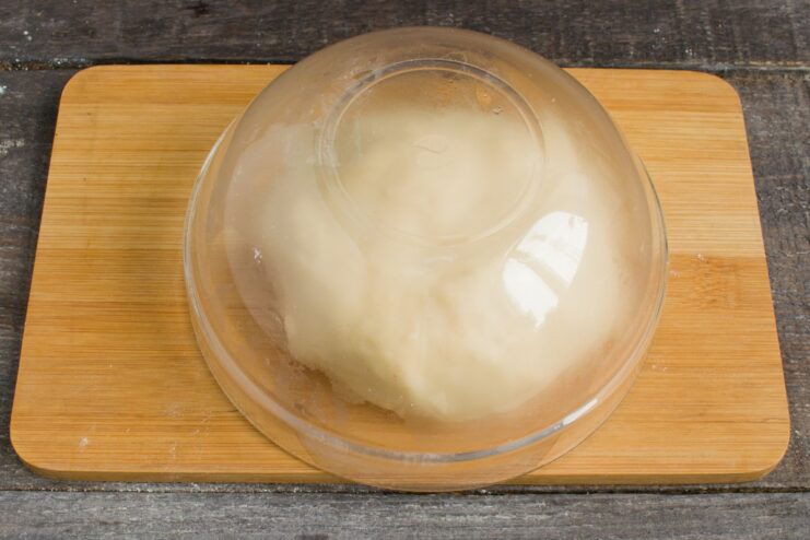 Step 2: Kneading the simple noodle dough until smooth A ball of smooth, elastic dough for homemade noodles on a wooden surface.