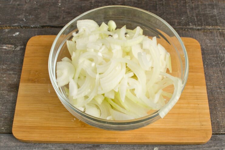 Preparing the aromatics: finely chopping the onion A pile of finely chopped yellow onion on a cutting board.