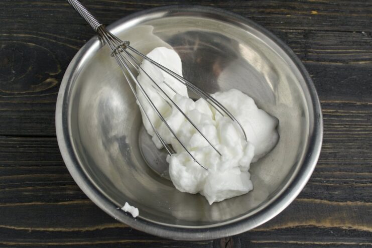 Whipping Egg Whites to Soft Peaks Egg whites being whipped with a hand mixer in a bowl until they form soft peaks.