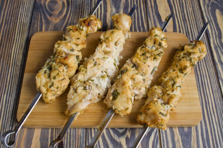 Golden Brown Chicken Shashlik Fresh from the Oven Cooked chicken shashlik on skewers resting on a baking sheet lined with foil.
