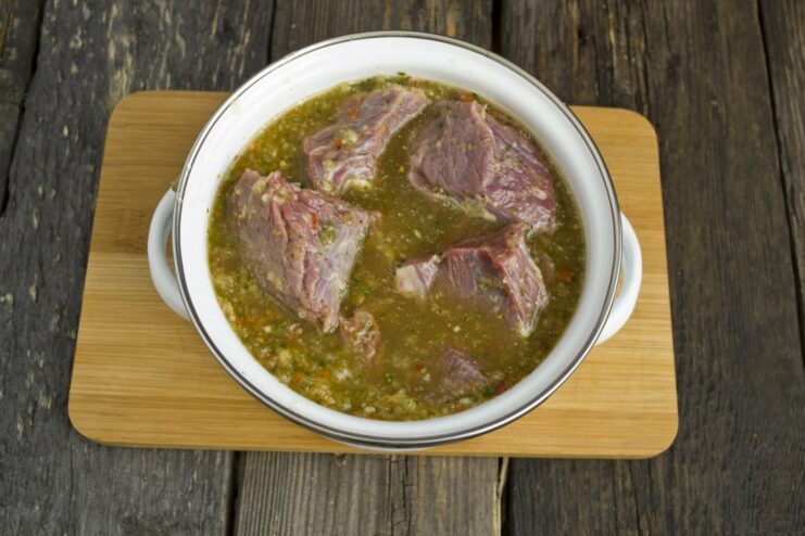 Marinating the Beef for Maximum Flavor and Tenderness Cubes of beef being mixed into the marinade in a bowl before chilling.