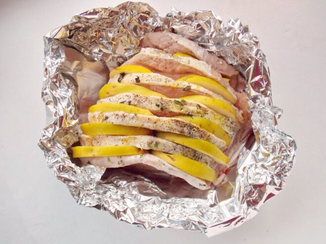 Initial Roasting to Sear the Pork A baking dish with pork and quince on foil, ready to go into the oven uncovered.