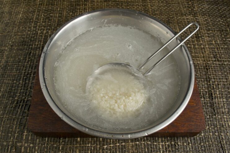 How to Perfectly Cook Rice for Homemade Sushi A pot of cooked white rice, ready for making sushi.