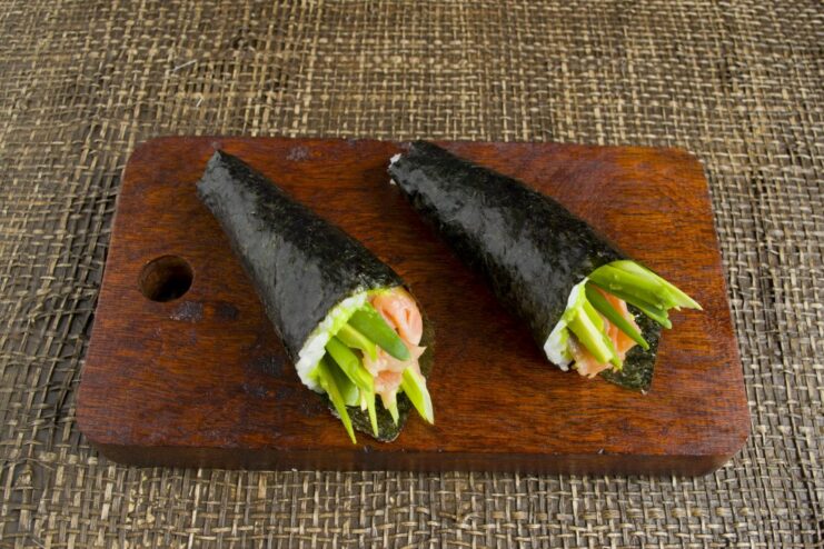 Serving Freshly Made Temaki Sushi with Dips Finished temaki sushi hand roll served with soy sauce and wasabi.
