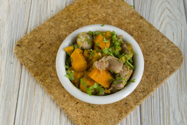 The final dish: a comforting bowl of stewed chicken gizzards with pumpkin. A close-up shot of the finished stewed chicken gizzards with pumpkin in a bowl.