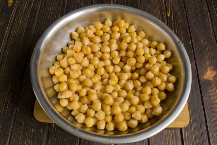 Boil the soaked chickpeas until tender before adding them to the main dish Soaked chickpeas boiling in a pot of water.