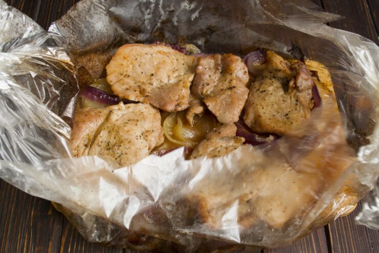 Bake the pork until it's cooked through and tender The baking sleeve with pork and onions baking inside an oven.